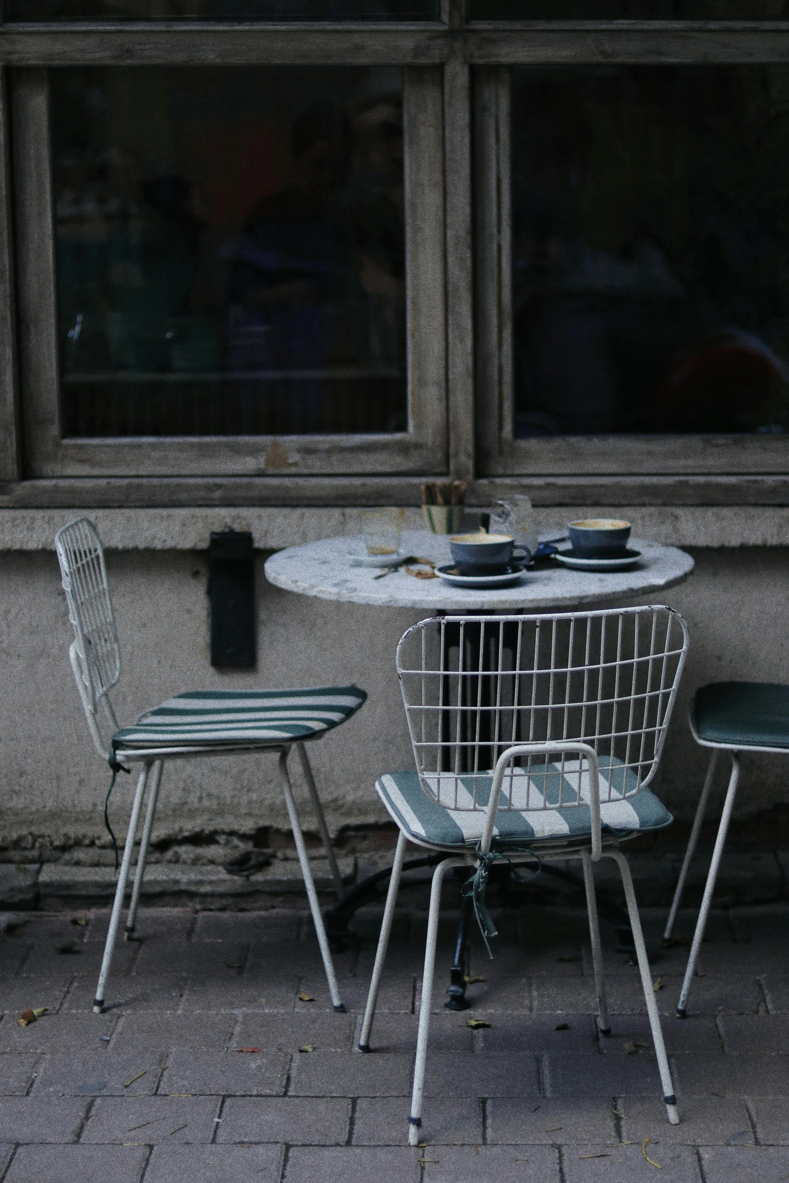 a couple of chairs sitting next to a table, a photo, trending on unsplash, post - soviet courtyard, coffee shop, square, place setting