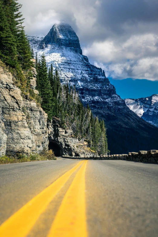 a wide road lined with yellow lines in the mountains