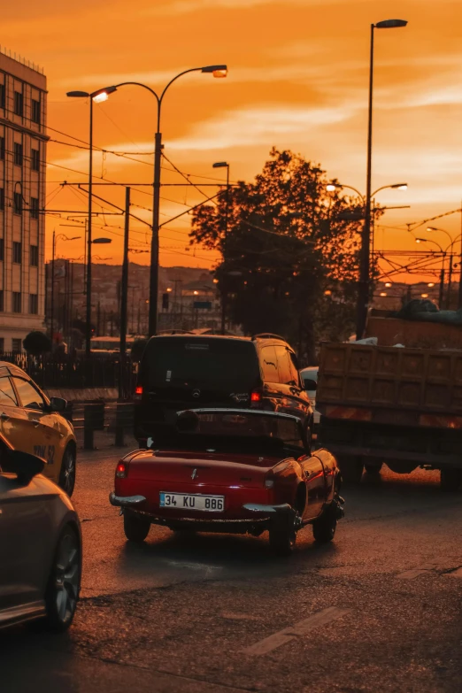 cars that are sitting in the street at sunset