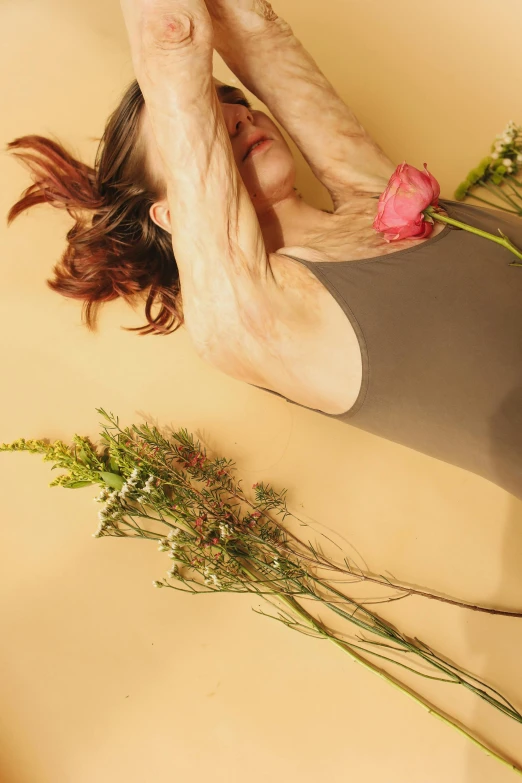 a  woman holding onto some flowers while laying on the ground