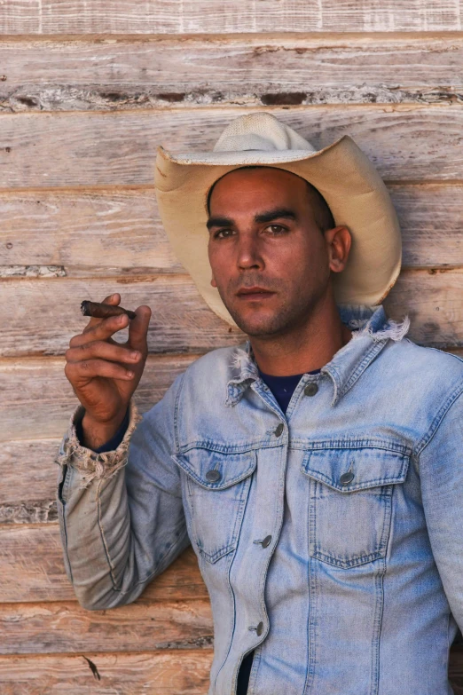 a man in a cowboy hat smoking a cigarette