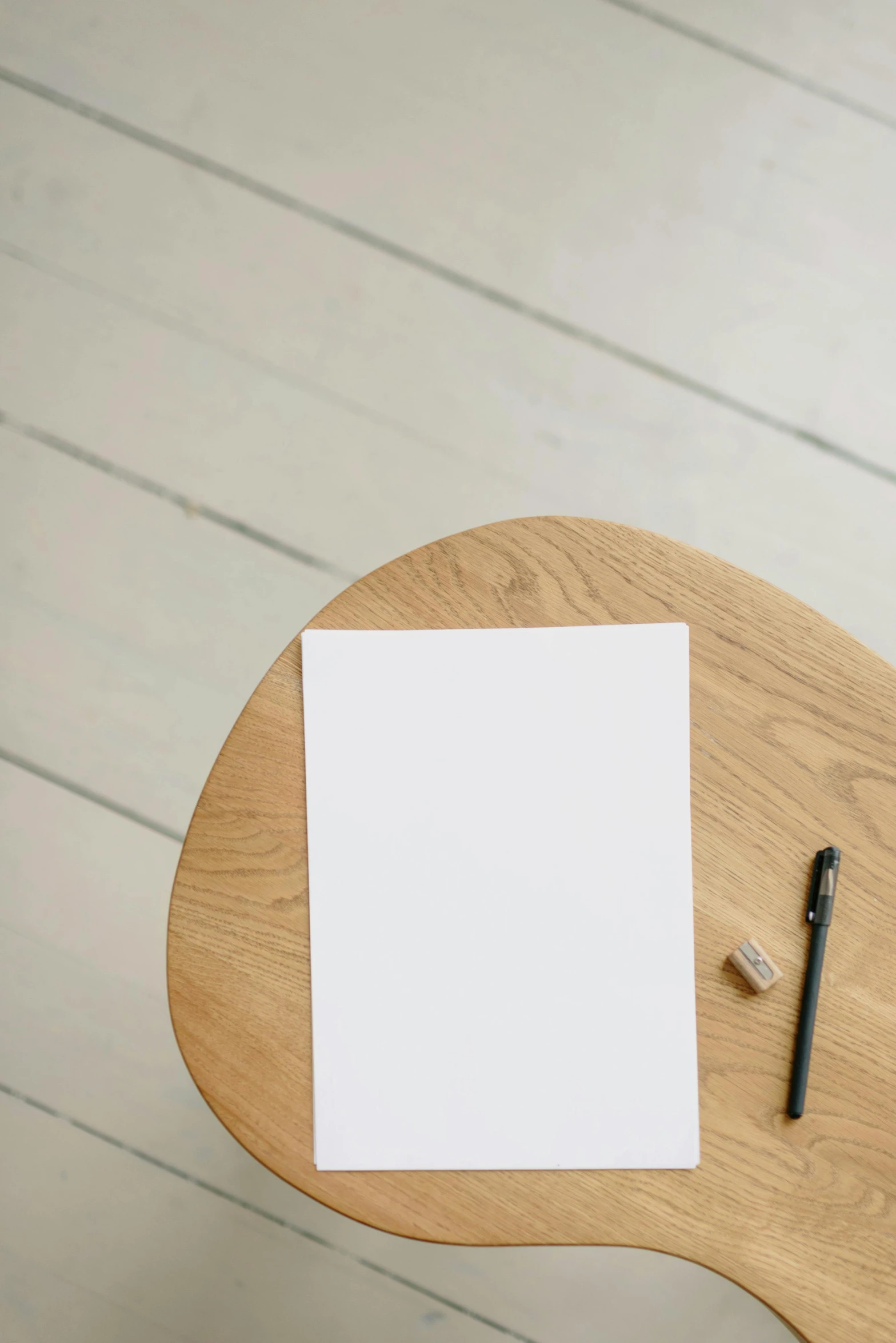 the white piece of paper on the desk has a pen