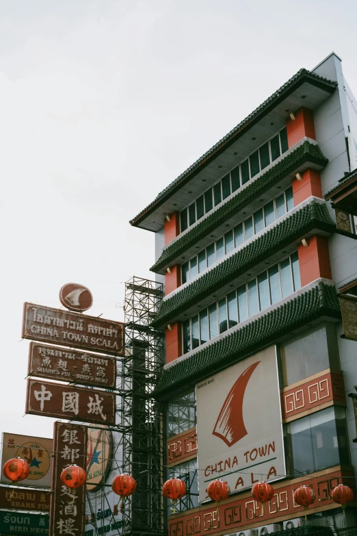 a red and white building with chinese signs surrounding