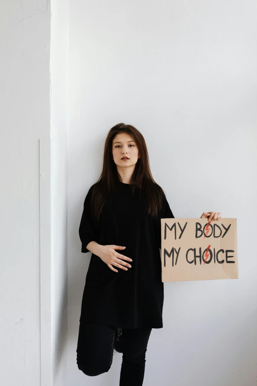 an asian woman holding a sign that says my body is my choice