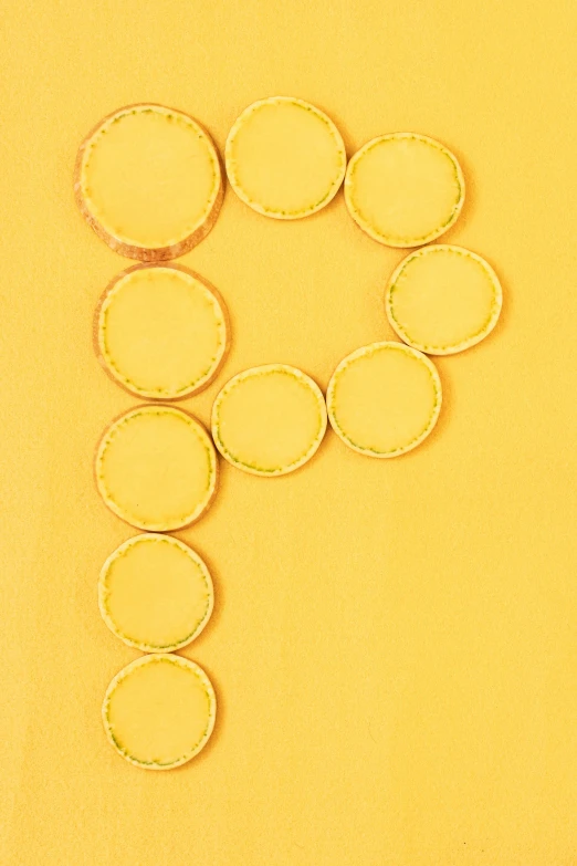 the numbers 6 made from doughnut holes on a yellow surface