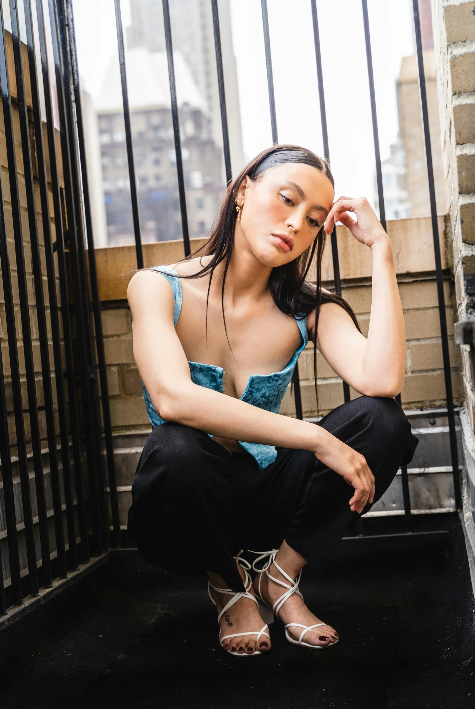 a young woman is posing on stairs wearing sandals