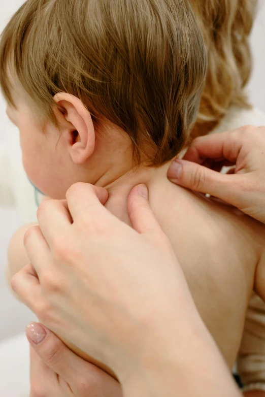 a person is giving the baby a ear massage