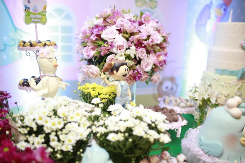 flowers are on display next to cakes and figurines