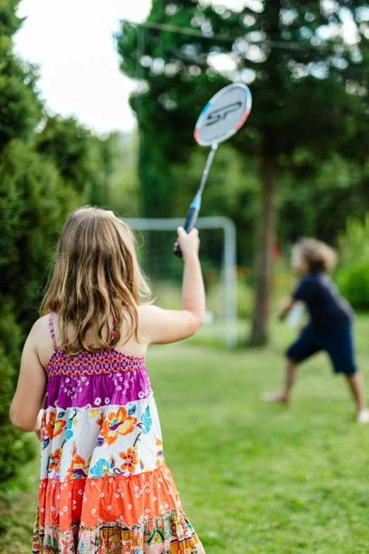 the little girl is holding a plastic stick outside