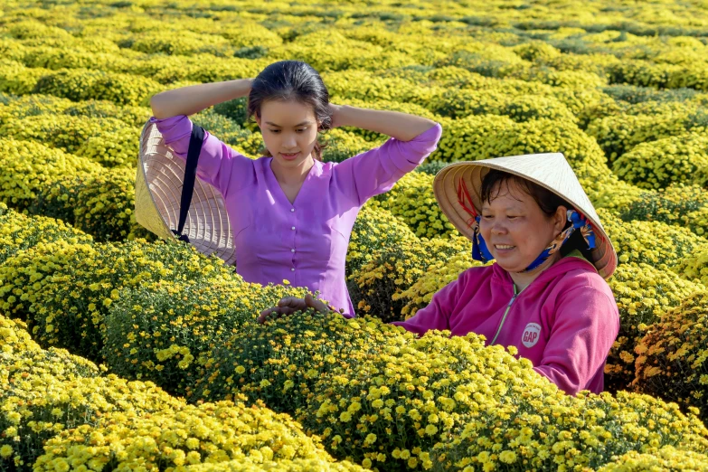 two women are in a field with green plants