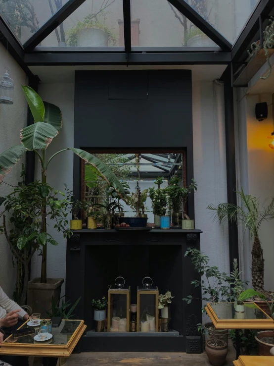 an outside space with plants, candles and a fire place