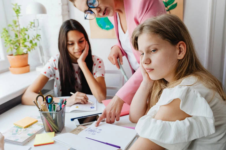 a group of s sitting around a table with some paper and pens