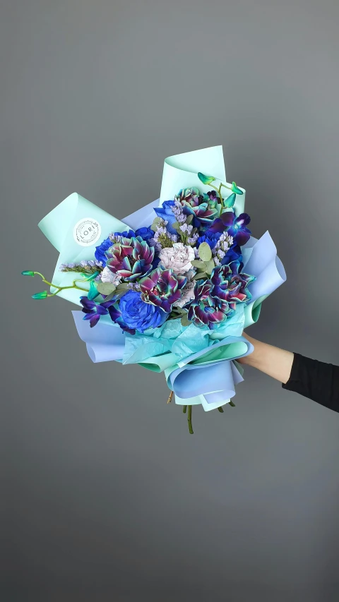 the woman is holding the blue paper flowers in front of her face