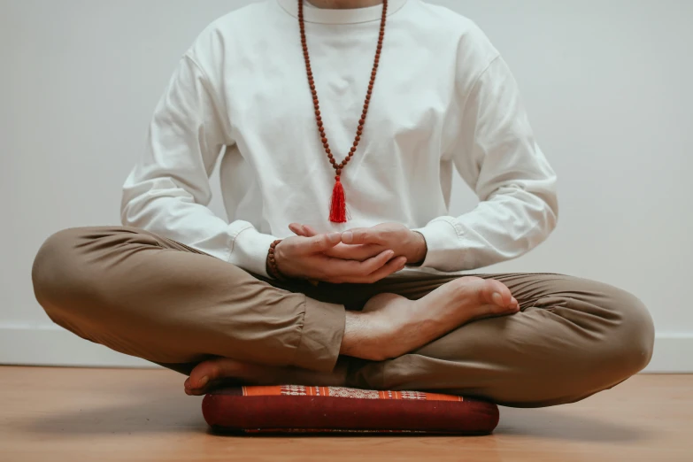 the man is sitting in a meditation position