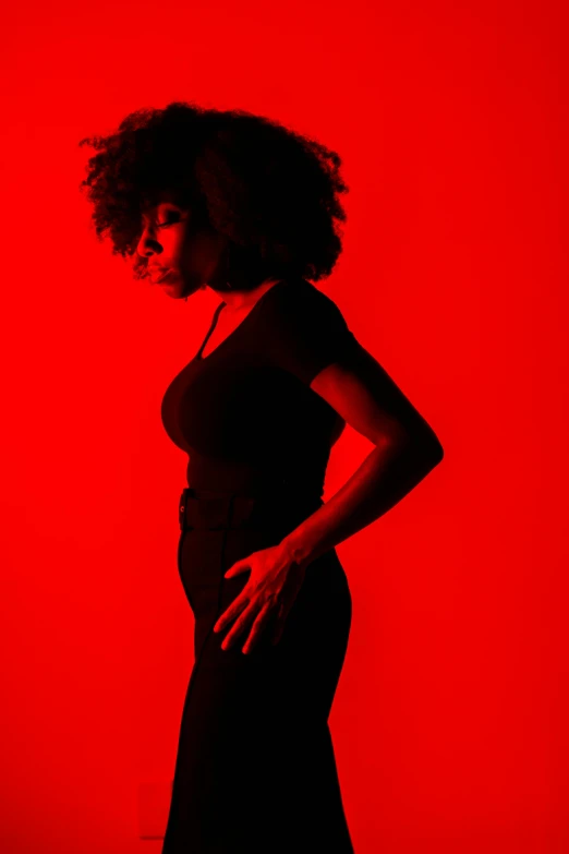 a woman standing in front of a red wall