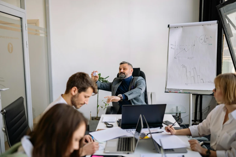 a man speaking to colleagues in a board room