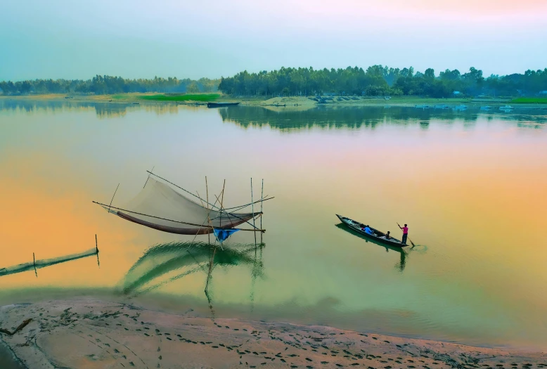 two boats are tied to poles on the river bank