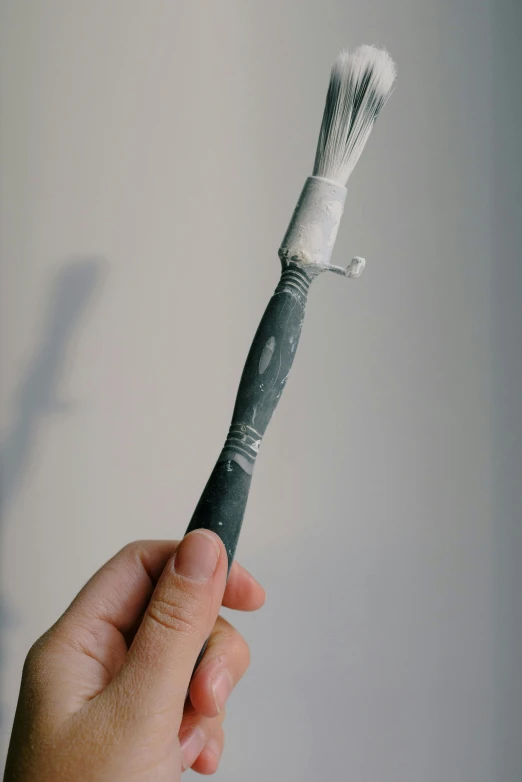 a person holding a toothbrush in the shape of a tube