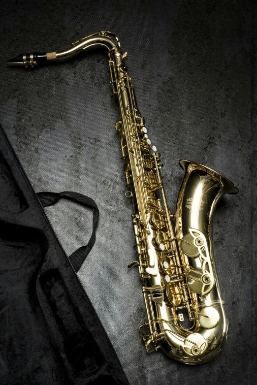 a gold saxophone resting on a black sheet