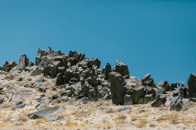 large rocks and small boulders against a blue sky