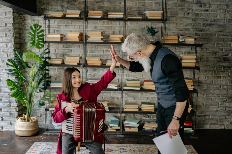 a man is talking to a woman while she plays the accordion