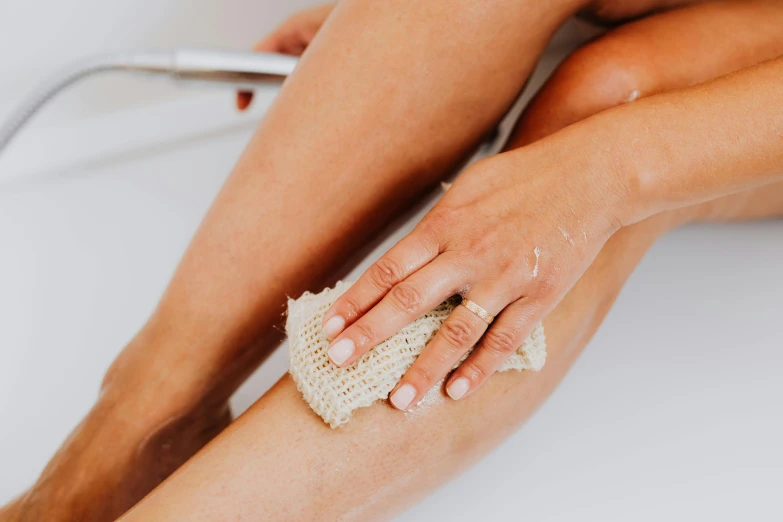 a woman with a scrub on her foot holding a sponge