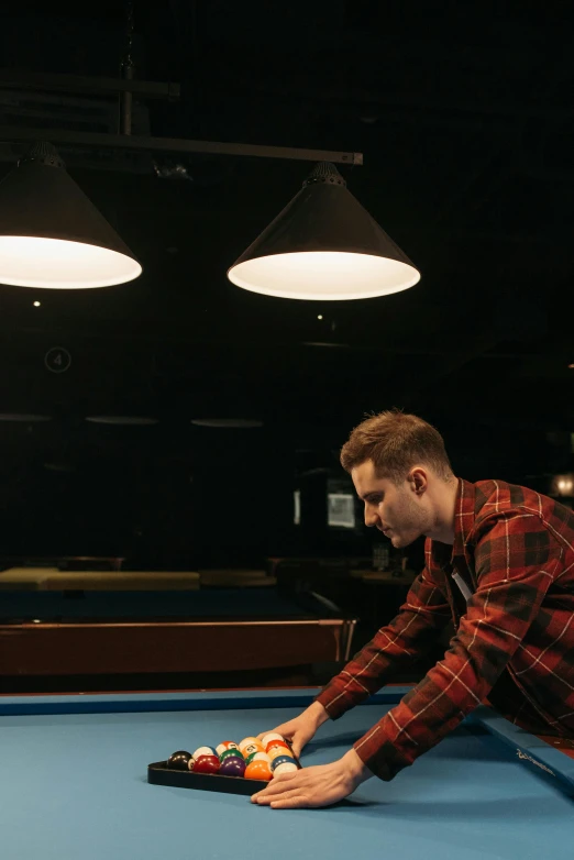 a man playing pool with his hands on the ball