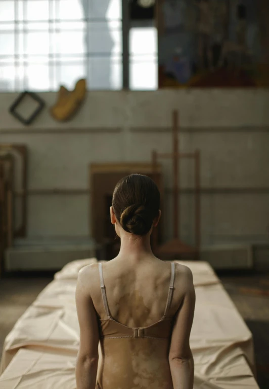 a woman standing on top of a sheet covered bed