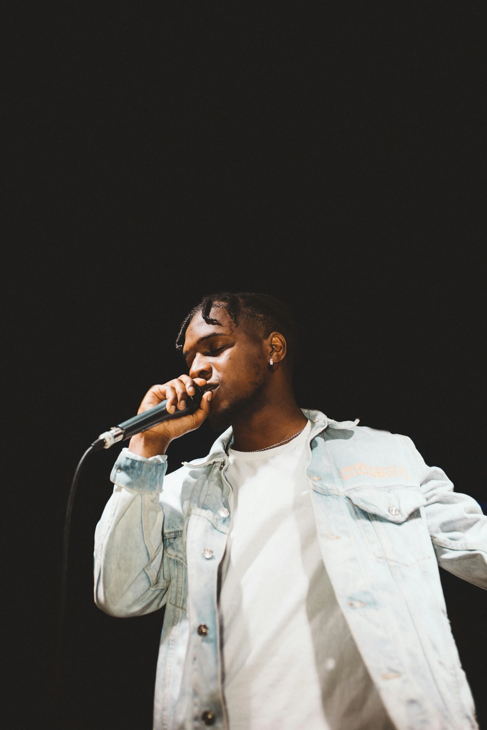 a man standing on top of a stage holding a microphone