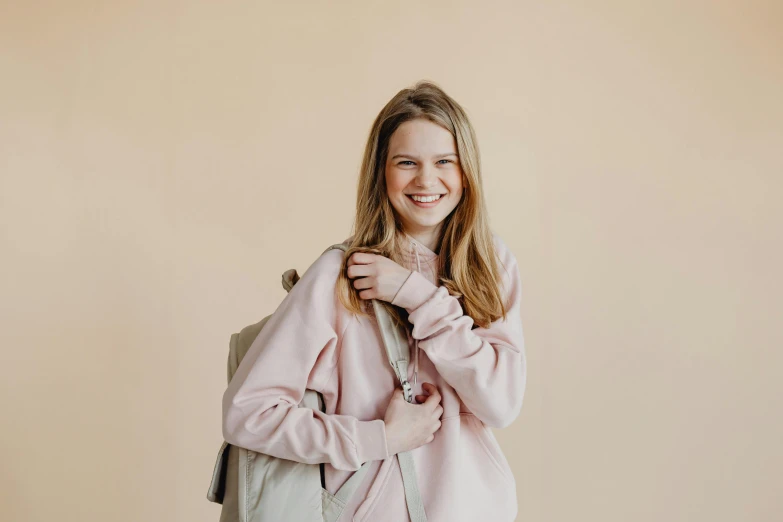 a woman is smiling as she holds on to her pink jacket