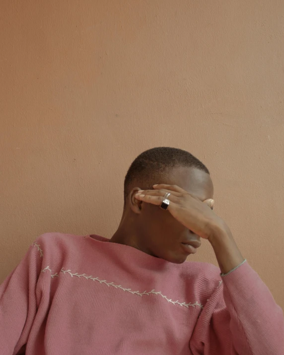 a young person is leaning against the wall