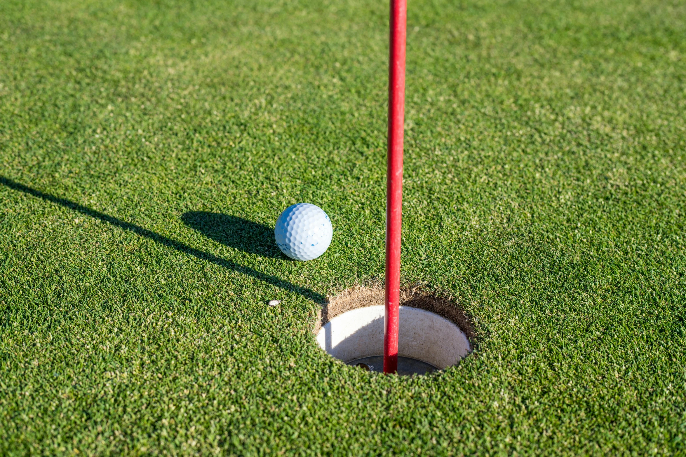 a golf ball next to a tee with a hole in the middle