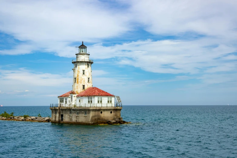 a white and red lighthouse sitting on top of water