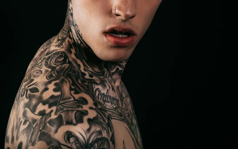 tattooed man with eye makeup and dark hair