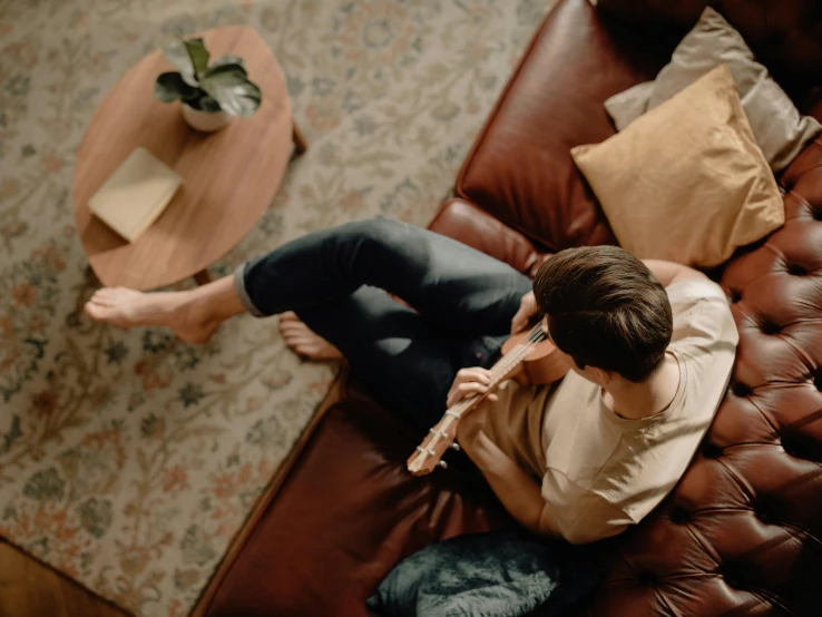 a woman sitting on a leather couch holding a cell phone