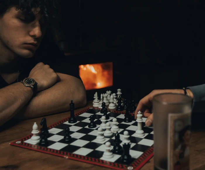 a person playing chess with another sitting at the table