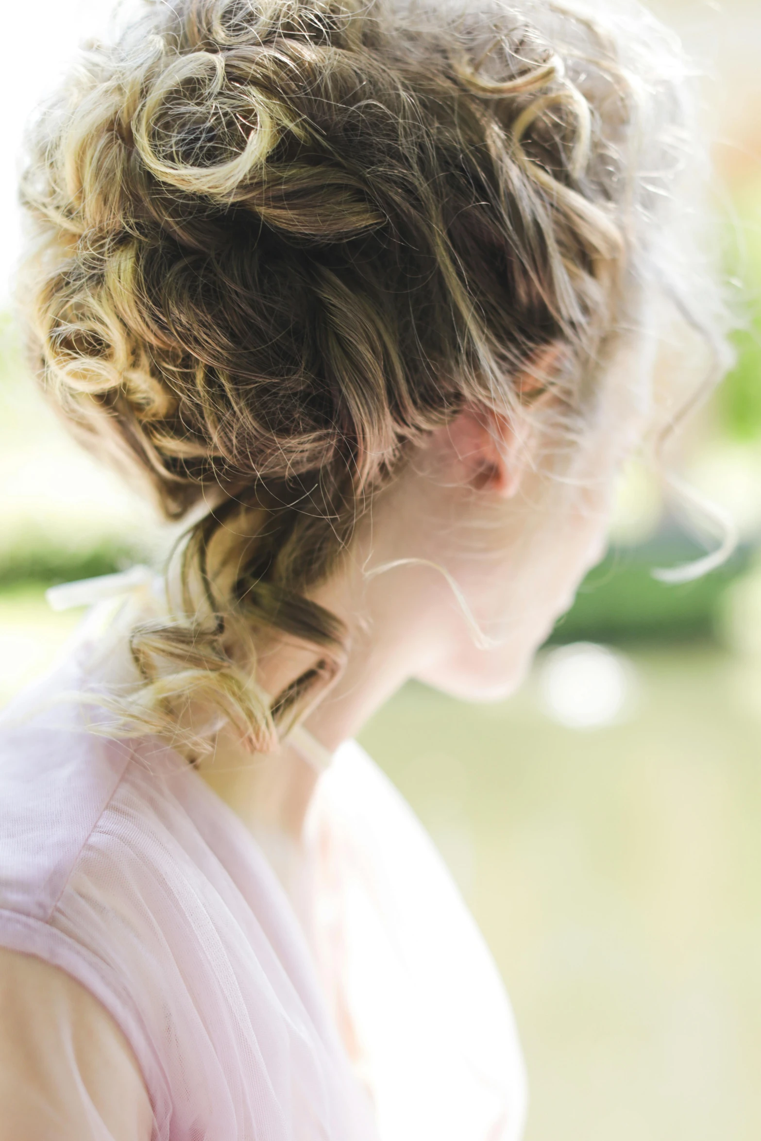 an image of the back of a woman's head with curls in her hair