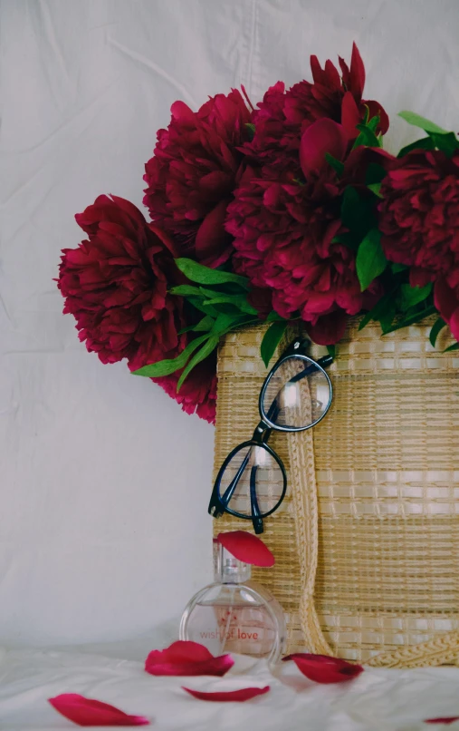 red flowers and some glasses on a white cloth