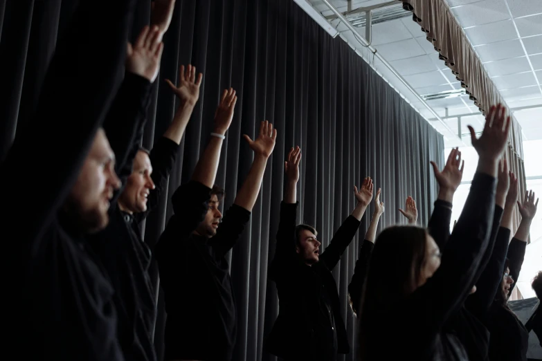 several people are raising their hands up