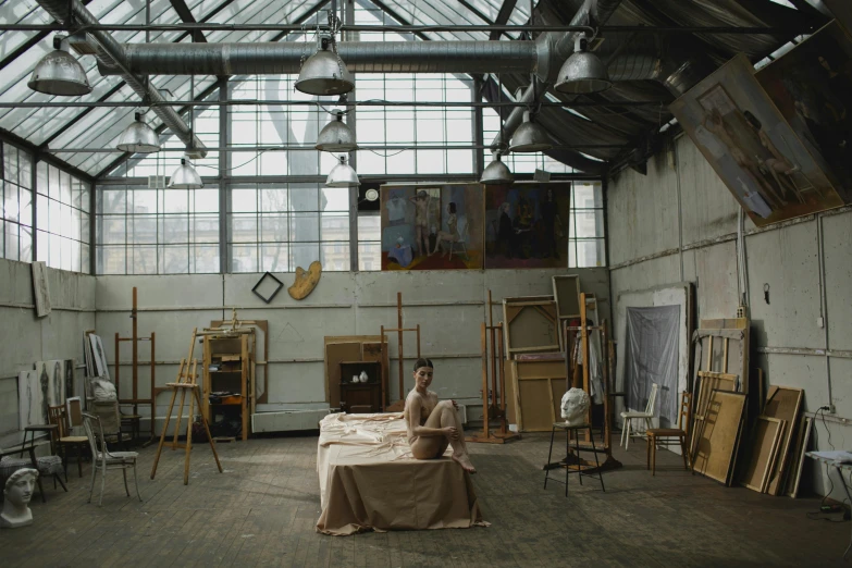 an artistic studio with chairs, paintings and an artist