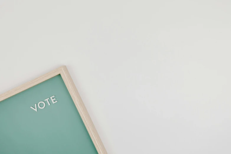 a vote is written on a green board on a white surface