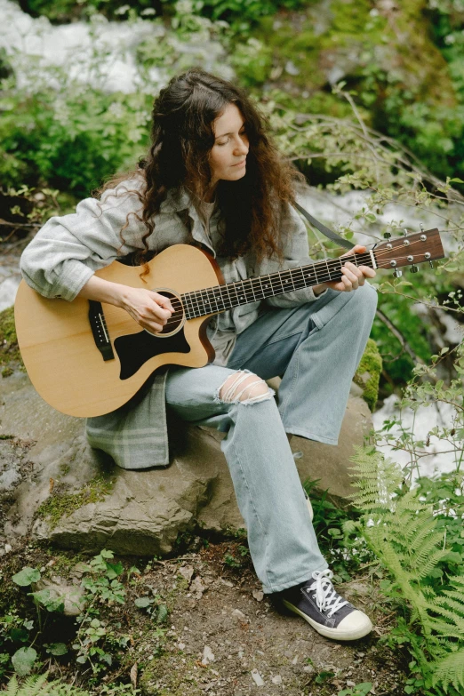 a person sitting down holding a guitar