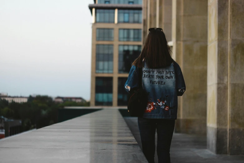 woman walking down a long sidewalk with a backpack