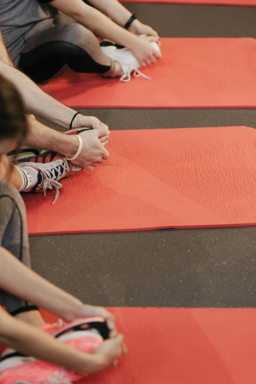 a group of people sitting on the ground with a red mat