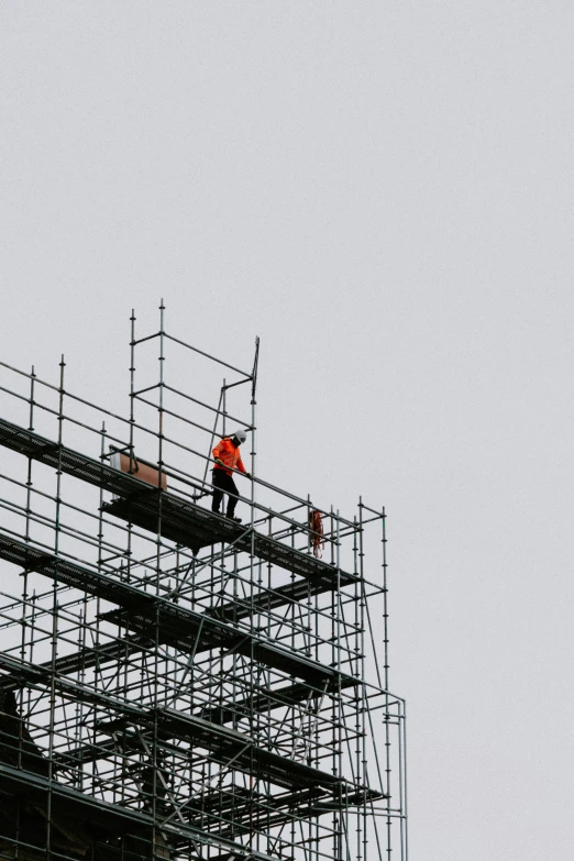 a man on a scaffolding roof working on a building