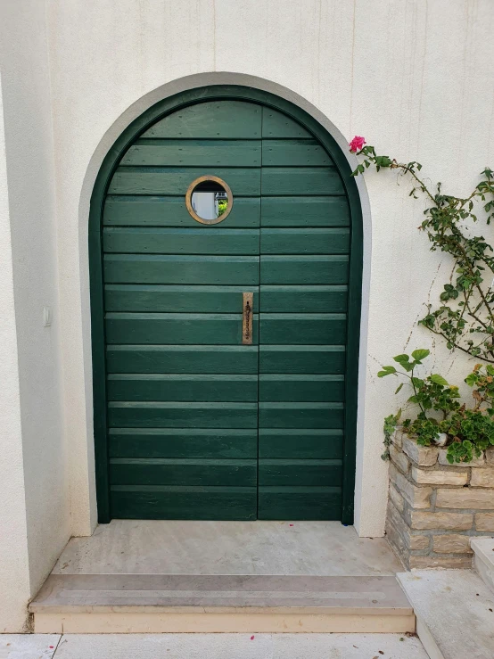 a green door with a circular circle on top