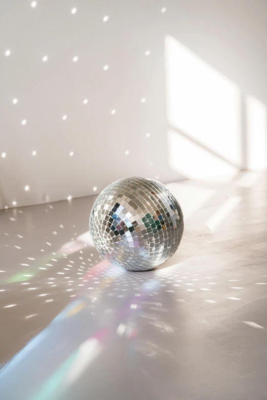 a disco ball on the floor against a wall