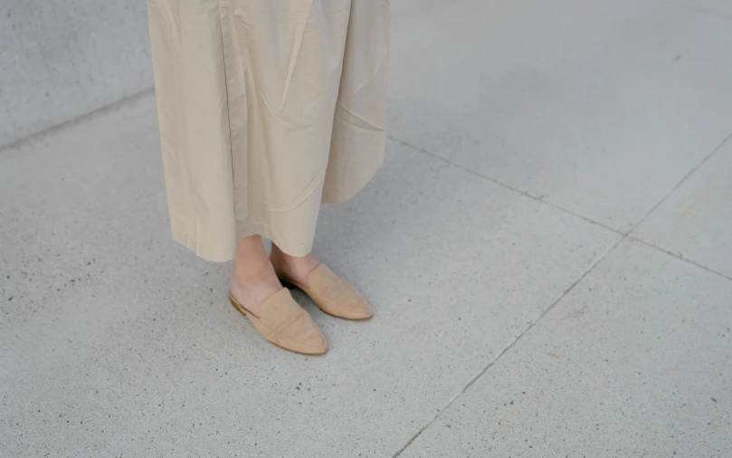 woman with slippers on standing on sidewalk with umbrella