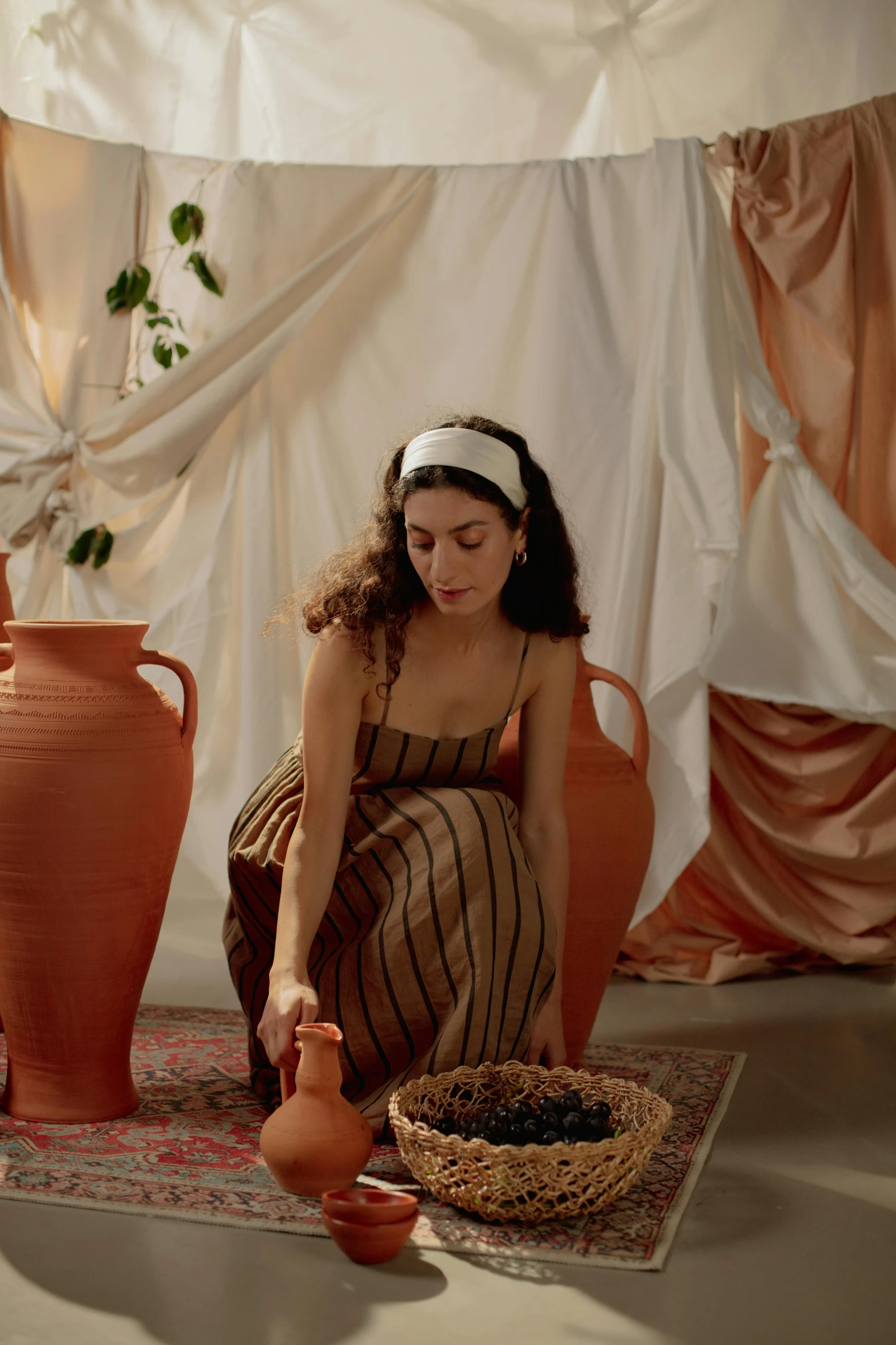 a woman sitting on the floor next to some large pots