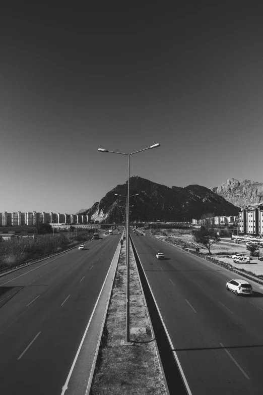 a view down an empty freeway and mountains in the background